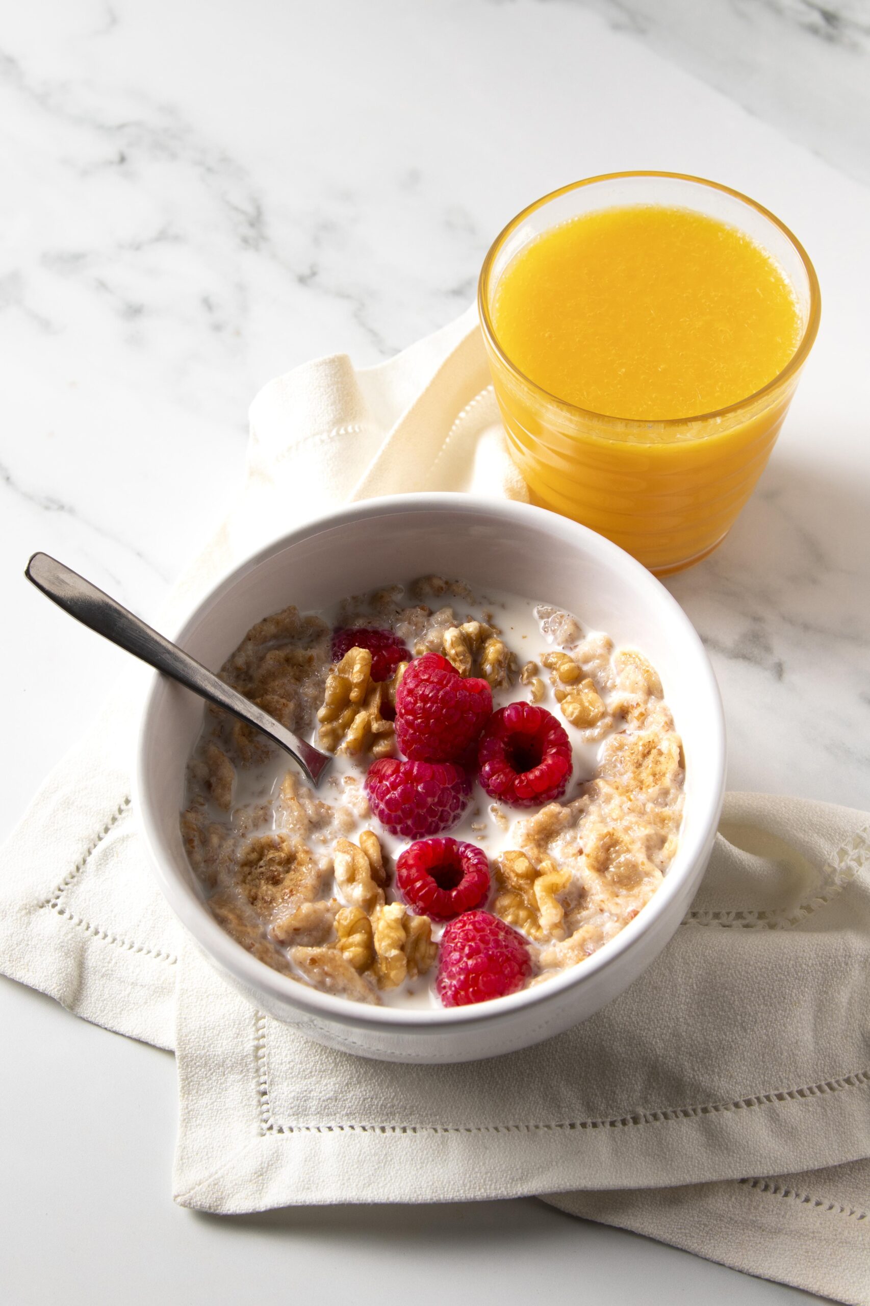 high-angle-composition-healthy-bowl-cereals-with-orange-juice (1)